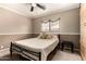 A bedroom features a black metal bed frame, neutral decor, a ceiling fan, and carpeted floors at 13359 W Post Dr, Surprise, AZ 85374