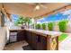 Outdoor patio with a wooden bar, overhead fan, bar fridge and string lights at 13359 W Post Dr, Surprise, AZ 85374