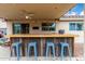 Covered outdoor bar area with overhead lighting, a ceiling fan, and bar stool seating at 13359 W Post Dr, Surprise, AZ 85374