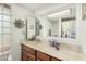 Bathroom with a large mirror and a floral decoration, reflecting a bathtub with shower at 134 E Le Marche Ave, Phoenix, AZ 85022