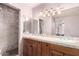Elegant bathroom with dual sinks, a large mirror, and a marble-lined shower for a spa-like experience at 134 E Le Marche Ave, Phoenix, AZ 85022