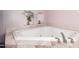 Relaxing corner jacuzzi bathtub with marble detailing, perfect for unwinding after a long day at 134 E Le Marche Ave, Phoenix, AZ 85022