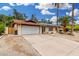Exterior view of a single-story home with a long concrete driveway and two-car garage at 134 E Le Marche Ave, Phoenix, AZ 85022