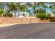 Street view of backyard brick privacy fence with gate and mature trees at 134 E Le Marche Ave, Phoenix, AZ 85022