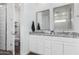 Bathroom with double granite vanity, two mirrors, and a door to the toilet at 14549 W Corrine Dr, Surprise, AZ 85379