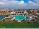 A stunning aerial view showcases a large community pool and amenities under a partly cloudy sky at 14549 W Corrine Dr, Surprise, AZ 85379