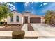 Inviting single-story home featuring a two-car garage and beautiful landscaping under a bright sky at 14549 W Corrine Dr, Surprise, AZ 85379