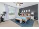 Main bedroom with a king bed, accent wall, and natural light, featuring an exercise bike at 14549 W Corrine Dr, Surprise, AZ 85379