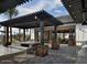 Inviting outdoor seating area with a pergola, tables, benches, grills, and stylish decor at 14549 W Corrine Dr, Surprise, AZ 85379