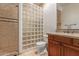 Bathroom featuring a walk-in shower with glass block, tile backsplash, and dark wood cabinets at 14619 E Desert Vista Trl, Scottsdale, AZ 85262