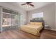 Bedroom featuring wood floors, a ceiling fan, and sliding glass doors leading to the backyard area at 14619 E Desert Vista Trl, Scottsdale, AZ 85262