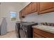 Laundry room featuring front load washer and dryer, granite counters, and wood cabinets at 14619 E Desert Vista Trl, Scottsdale, AZ 85262