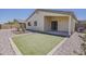 Well-kept backyard with artificial turf, low-maintenance desert landscaping, and covered patio at 1726 E Primera Dr, Casa Grande, AZ 85122
