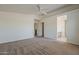 Open bedroom layout featuring neutral carpet, a ceiling fan, and access to the bathroom at 1726 E Primera Dr, Casa Grande, AZ 85122
