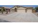 Front exterior view showing a three-car garage and desert landscaping at 1726 E Primera Dr, Casa Grande, AZ 85122