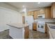 Bright kitchen boasts white appliances, wood cabinets, and a kitchen island at 1726 E Primera Dr, Casa Grande, AZ 85122