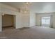 Bright living room featuring neutral carpet, chandelier, and a large window with curtains at 1726 E Primera Dr, Casa Grande, AZ 85122