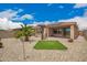 Landscaped backyard featuring a built-in grill, covered patio, gravel ground cover, and small grassy area at 17907 W Cedarwood Ln, Goodyear, AZ 85338