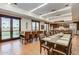 Bright dining room with hardwood floors, modern lighting, multiple tables, and adjacent kitchen area at 17907 W Cedarwood Ln, Goodyear, AZ 85338