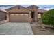 Charming single story home featuring a stone accent entry, two car garage, and a well maintained front yard at 17907 W Cedarwood Ln, Goodyear, AZ 85338