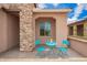 Inviting front porch with stone accents and outdoor seating with a pineapple and drinks at 17907 W Cedarwood Ln, Goodyear, AZ 85338
