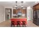 Spacious kitchen features a red island, stainless steel appliances, granite counters, and stylish pendant lighting at 17907 W Cedarwood Ln, Goodyear, AZ 85338