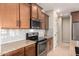 Close up of the kitchen with stainless steel appliances, granite counters, and white subway tile backsplash at 17907 W Cedarwood Ln, Goodyear, AZ 85338