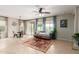 Spacious living room featuring a ceiling fan, tile flooring, large windows, curtains and comfortable furnishings at 17907 W Cedarwood Ln, Goodyear, AZ 85338