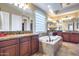 Luxurious bathroom featuring a soaking tub, double sinks, and granite countertops at 19414 W Pasadena Ave, Litchfield Park, AZ 85340