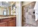 Well-appointed bathroom features a granite countertop vanity and a tiled walk-in shower with modern fixtures at 19414 W Pasadena Ave, Litchfield Park, AZ 85340