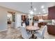 Cozy dining area with a round table, seating for four, and stylish light fixture adjacent to the kitchen at 19414 W Pasadena Ave, Litchfield Park, AZ 85340