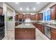 Well-lit kitchen with dark wood cabinetry, granite countertops, and updated appliances at 19414 W Pasadena Ave, Litchfield Park, AZ 85340