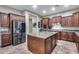 Modern kitchen featuring dark wood cabinets, stainless steel appliances, and granite countertops at 19414 W Pasadena Ave, Litchfield Park, AZ 85340