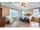 Serene main bedroom offers ample natural light, tile flooring, and comfortable seating with a neutral color palette at 19414 W Pasadena Ave, Litchfield Park, AZ 85340