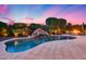 Beautiful pool featuring a rock waterfall and lush landscaping, perfect for relaxing evenings at 19414 W Pasadena Ave, Litchfield Park, AZ 85340