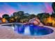 Beautiful pool area featuring a rock waterfall and lush landscaping, perfect for relaxation at 19414 W Pasadena Ave, Litchfield Park, AZ 85340