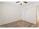 This bedroom features wood-look flooring, a ceiling fan, and a mirrored closet at 1945 W Renaissance Ave, Apache Junction, AZ 85120