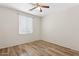 This bedroom features wood-look flooring, a ceiling fan, and a bright window at 1945 W Renaissance Ave, Apache Junction, AZ 85120
