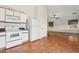 A functional kitchen featuring classic appliances, white cabinetry, and a seamless transition into the living area at 1945 W Renaissance Ave, Apache Junction, AZ 85120