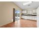Bright kitchen with white cabinets, tile flooring, full appliances, and a sliding door to the outdoor space at 1945 W Renaissance Ave, Apache Junction, AZ 85120