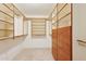 A spacious walk-in closet has built-in shelving and wooden drawers for maximum storage at 1945 W Renaissance Ave, Apache Junction, AZ 85120