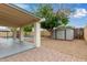 Covered patio featuring a brick floor, leading to a pool and large storage shed at 2006 N Arrowhead Dr, Chandler, AZ 85224