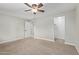 Bedroom with neutral carpet, ceiling fan, a doorway, and a walk-in closet at 2006 N Arrowhead Dr, Chandler, AZ 85224