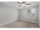 Carpeted bedroom with a ceiling fan and window overlooking the outdoors at 2006 N Arrowhead Dr, Chandler, AZ 85224