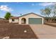 Home's exterior featuring a green garage door, desert landscaping, and an arched front entryway at 2006 N Arrowhead Dr, Chandler, AZ 85224