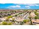 Wide aerial view of a community with solar panels on roofs, trees, desert landscaping, and wide streets at 20642 N 268Th Dr, Buckeye, AZ 85396