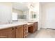 A primary bathroom featuring dual sinks, vanity area, wood cabinets, and a glass-enclosed shower at 20642 N 268Th Dr, Buckeye, AZ 85396