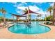 Resort-style community pool with sunshades, ample seating, and tropical landscaping at 20642 N 268Th Dr, Buckeye, AZ 85396