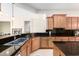 Beautiful kitchen with granite countertops, wooden cabinetry, stainless steel appliances, and tile flooring at 20642 N 268Th Dr, Buckeye, AZ 85396