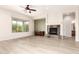 Living room with a corner fireplace, large view window, and light wood flooring at 20642 N 268Th Dr, Buckeye, AZ 85396